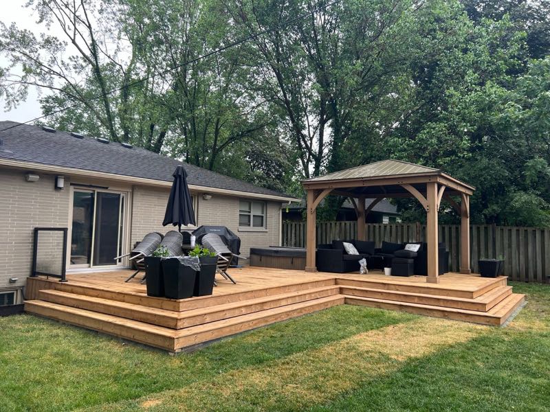 Wide backyard deck with steps and a gazebo