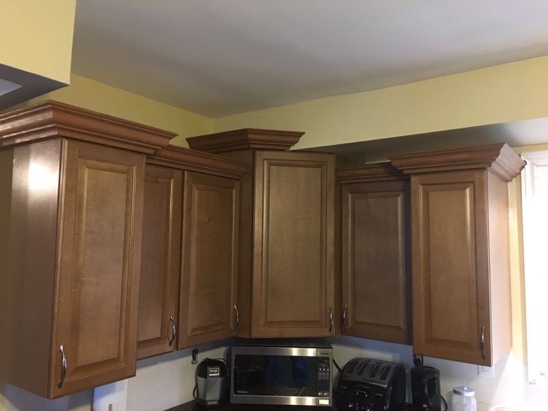 Wood kitchen cabinets with raised-panel doors and crown moulding