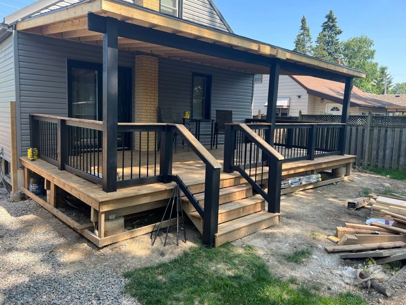 Wood porch and steps with black posts and railings